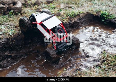 Spielzeug rc Auto steigt aus der Pfütze von Schlamm Stockfoto