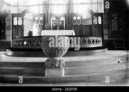 Interieur von Bräkne-Hoby Kirche, erbaut 1868-1872. Das Taufbecken aus dem 13.. Jahrhundert, aus Sandstein aus dem Åhustrak gefertigt und geschnitzt. Stockfoto