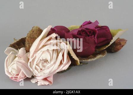 Blomma Hut Blumen. Ein lila und zwei rosa Rosen aus Stoff. Samtblatt. Position des Stahldrahts. Wurde von Frau Elise Ruben verwendet. Geboren 1861-08-23, verlobt 1880. Verheiratet 1881-09-11 in Hamburg mit Großhändler Anton Ruben. Eigenes Haus auf Drottninggatan 48, Karlskrona, und das Grundstück Avvelsgärde in der Gemeinde der Loose. Frau Ruben starb am 1933-02-23. Die Gegenstände, die irgendwann in der Zeit von 1880-1906. Geschenk im Jahr 1942 von Agronom Edvard Ruben, AvVelsgärde. Stockfoto