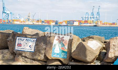 Gemälde auf Steinen im Hafen von Las Palmas de Gran Canary Spanien, im Hintergrund sieht man den Industriehafen Stockfoto