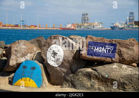 Gemälde auf Steinen im Hafen von Las Palmas de Gran Canary Spanien, im Hintergrund sieht man den Industriehafen Stockfoto