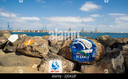 Gemälde auf Steinen im Hafen von Las Palmas de Gran Canary Spanien, im Hintergrund sieht man den Industriehafen Stockfoto