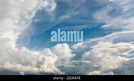 Weiße, flauschige Wolken am blauen Himmel. Hintergrund aus Wolken. Stockfoto