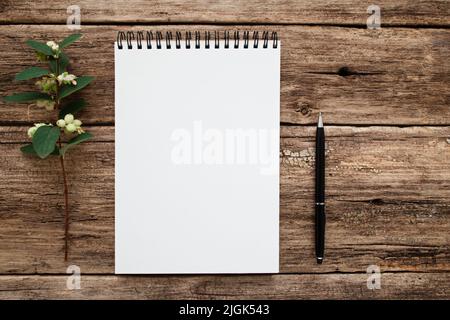 Leeres weißes Notizbuch mit Blumen und flacher Stiftlage Stockfoto