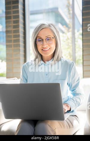 Ältere Frau arbeitet als Freiberuflerin am Laptop in einem Coworking. Stockfoto