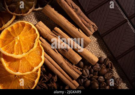 Orange, Zimt, Sternanise, Kaffeebohnen und dunkle Schokolade aus nächster Nähe Stockfoto