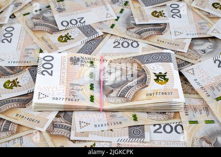 Hintergrund aus polierten 200 Zloty-Banknoten mit Bundle in der Mitte. Finanzstruktur abstrakt. Stockfoto