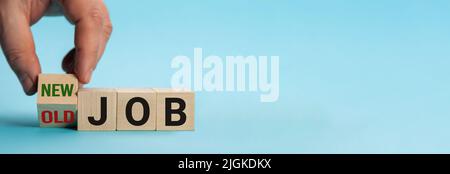 Alter Job und neuer Job, Karriere verändern das konzeptuelle Image. Hand dreht Holzwürfel und ändert den Ausdruck alter Job in neuen Job. Stockfoto