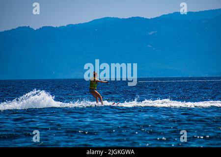Frau genießt Wasserski am Koukounaries Strand auf der Insel Skiathos, Sporaden, Griechenland Stockfoto
