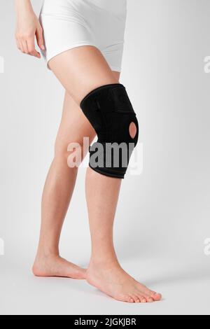 Kniestützenstrebe am Bein isoliert auf weißem Hintergrund. Elastische orthopädische Orthese. Anatomische Hosenträger für Kniefixierung, Verletzungen und Schmerzen. Schutz Stockfoto