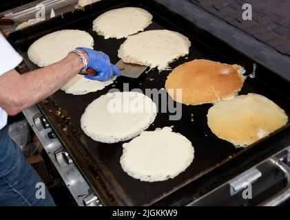 Freiwillige kochen Pfannkuchen bei der jährlichen Spendenveranstaltung des Rotary Club „Pancakes in the Park“ in Santa Fe, New Mexico. Stockfoto