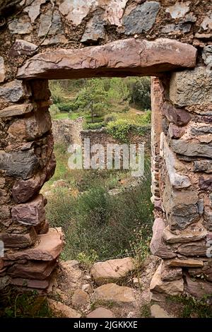 Jinquer, Castellon, Spanien. Häuser in Ruinen eines verlassenen Dorfes in der Mitte der Vegetation.Berg, Gruppe von Häusern. Straßen, Spanischen Bürgerkrieg Stockfoto