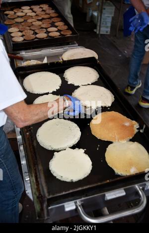 Freiwillige kochen Pfannkuchen bei der jährlichen Spendenveranstaltung des Rotary Club „Pancakes in the Park“ in Santa Fe, New Mexico. Stockfoto