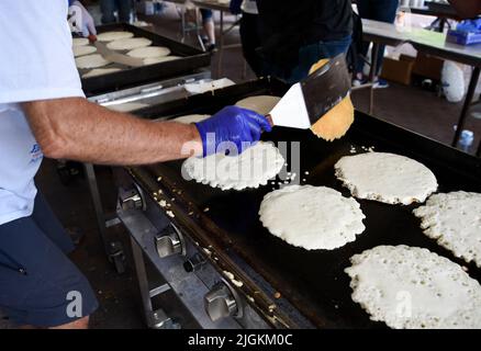 Freiwillige kochen Pfannkuchen bei der jährlichen Spendenveranstaltung des Rotary Club „Pancakes in the Park“ in Santa Fe, New Mexico. Stockfoto