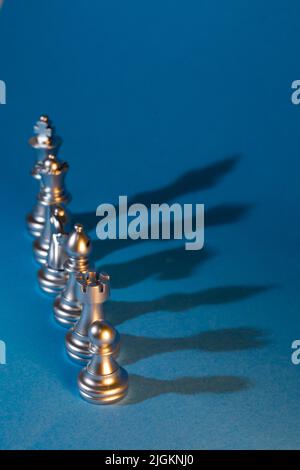 Silberne Schachfiguren auf blauem Hintergrund. Stockfoto