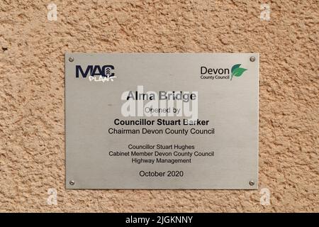 SIDMOUTH, DEVON, ENGLAND - 1. 2021. APRIL: Die Gedenktafel zur Eröffnung der neuen Alma Bridge in Sidmouth ist an einer Ziegelwand zu sehen Stockfoto