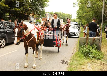 Ein buntes Pferd, das eine Falle entlang der Straße zieht, Appleby Horse Fair, Appleby in Westmorland, Cumbria Stockfoto