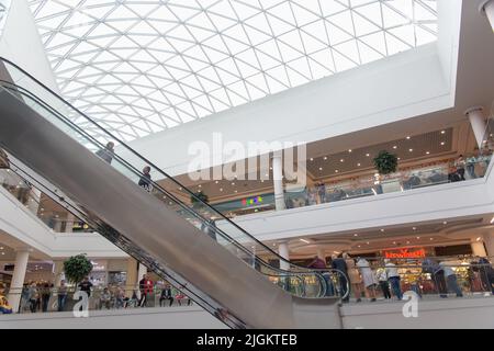 Grodno, Weißrussland - 01. September 2020: Besucher gehen durch die Stockwerke und bewegen sich auf Rolltreppen und Aufzügen im Einkaufszentrum TRINITI. Stockfoto