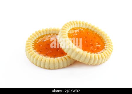 Zwei aprikosenfüllende, herb gehaltene Kekse auf weißem Hintergrund. Glänzende orangefarbene Leckereien Stockfoto