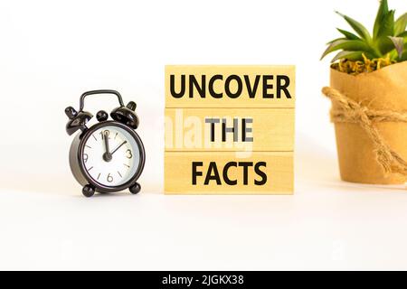 Entdecken Sie das Facts-Symbol. Concept Words enthüllen die Fakten auf Holzblöcken auf einem schönen weißen Hintergrund. Schwarzer Wecker. Unternehmen und Stockfoto