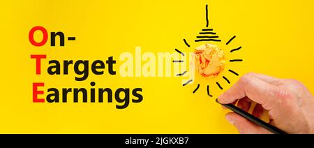 OTE-Symbol für die angestrebten Gewinne. Das Konzept formuliert die Zielgewinne des OTE auf gelbem Papier auf einem schönen gelben Hintergrund. Geschäftsmann Hand. Business und O Stockfoto