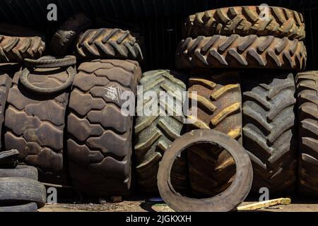 Goiânia, Goiás, Brasilien – 10. Juli 2022: In einem Fachgeschäft stapelten sich viele alte und schmutzige Reifen verschiedener Größen. Gummireifen, gebraucht. Stockfoto