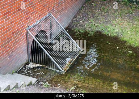 Metallgitter-Sturmablass-Filterbarriere. Sauberes Wasser Stadt Kanal Quelle. Rost Regen Abfluss Abwasser Müll Verschmutzung Schutz. Stadt in der Stadt Stockfoto