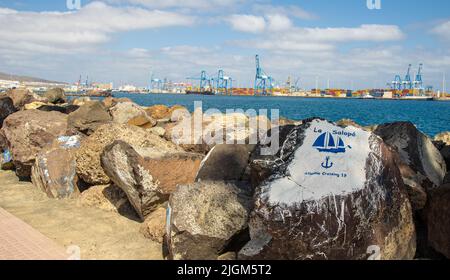 Gemälde auf Steinen im Hafen von Las Palmas de Gran Canary Spanien, im Hintergrund sieht man den Industriehafen Stockfoto