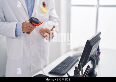 Junger hispanischer Mann Apotheker Scannen Pillen Flasche in der Apotheke Stockfoto