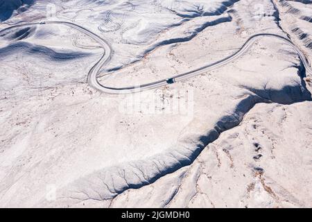 Feldweg in Utah Badlands. Fahrzeug und Person auf der Straße. Stockfoto