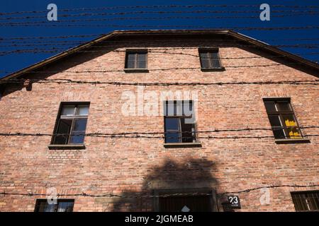 Barb Drahtzaun und Gebäude im ehemaligen Konzentrationslager Auschwitz I, Auschwitz, Polen. Stockfoto