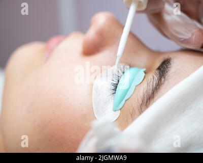 Junge Frau, die Wimpern färbt und laminiert. Stockfoto