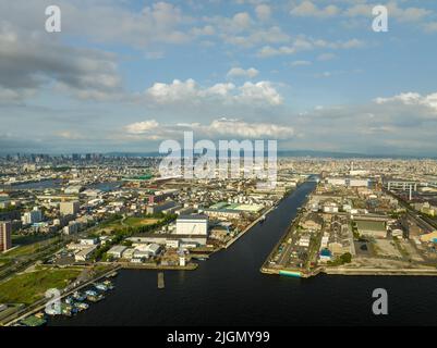 Kanal durch Industriehafen in Richtung weitläufige Stadt Stockfoto