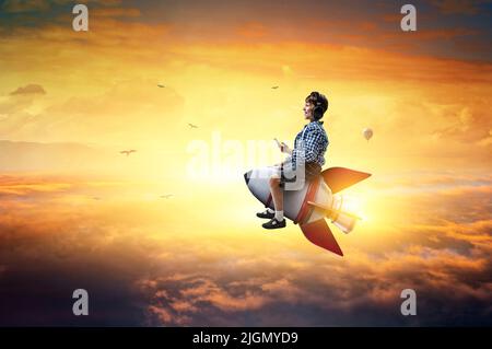Kind trägt Kopfhörer auf einer Rakete Stockfoto