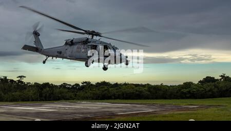 Ein US Navy Sikorsky SH-60 Seahawk Helikopter mit Hubschrauber-Seekampfgeschwader 85 steigt von einem Hubschrauberlandeplatz nach einem Luftgessperntraining während eines Urban Sniper Kurses auf Lager Schwab, Okinawa, Japan, 15. Juni 2022. Die Ausbildung der Luftwaffe wurde von Marines und militärischen Auftragnehmern mit der Expeditionary Operations Training Group geleitet, um die Fähigkeiten der teilnehmenden Marines in städtischen Umgebungen durch Präzisionsfeuer und das Einfangen simulierter Ziele aus einem Flugzeug zu verbessern. (USA Marine Corps Foto von Lance CPL. Jonathan Beauchamp) Stockfoto