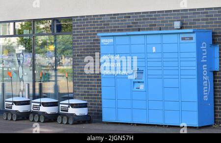 Raumschiff-Zustellroboter warten neben einem Amazon-Schließfach. Stockfoto