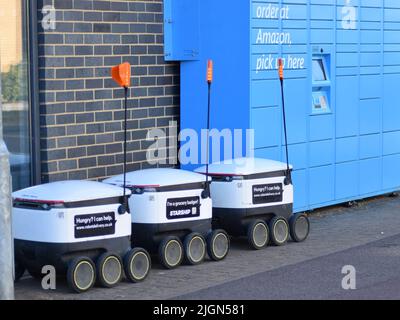 Raumschiff-Zustellroboter warten neben einem Amazon-Schließfach. Stockfoto