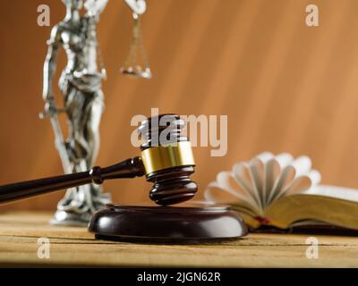 Richtergavel, Bronzegarnelle von Themis und ein offenes Buch Verfassung. Auf beigem Hintergrund. Rechtsstaatlichkeit, Gericht und Justiz. Es sind keine Personen drin Stockfoto