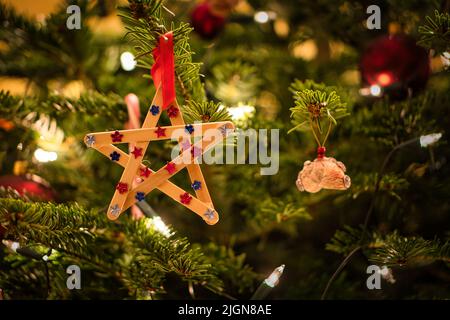 Weihnachten. Weihnachtsdekoration. Weihnachtsstern aus Holz hängt am Weihnachtsbaum. Christlicher Feiertag. Foto aus dem Leben Stockfoto