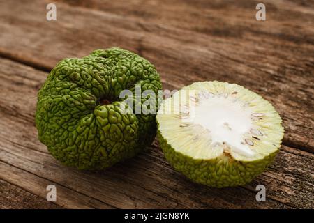 Osage orange und eine Hälfte auf Holz Nahaufnahme Stockfoto