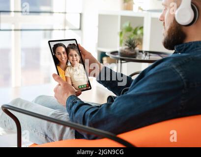 Mann mit digitalem Tablet-Video chattet mit Frau und Tochter Stockfoto
