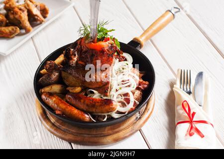 Pfanne mit gegrillten Fleischsnacks und Besteck Stockfoto