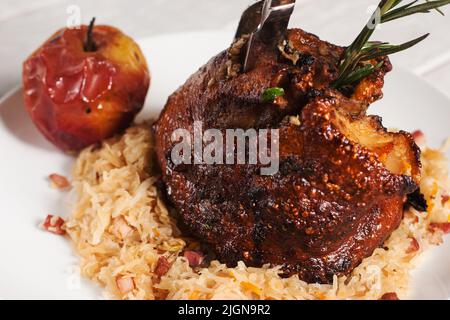 Gebackener Schinken mit gedünstetem Kohl und Apfel Stockfoto