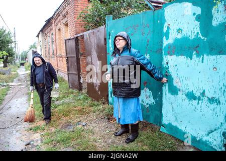 Nicht exklusiv: KHARKIV, UKRAINE - 11. JULI 2022 - Anwohner werden auf der Straße gesehen, während die Folgen des Beschuss durch die beseitigt werden Stockfoto