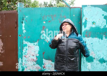 Nicht exklusiv: KHARKIV, UKRAINE - 11. JULI 2022 - Ein Einheimischer wird auf der Straße gesehen, während die Folgen des Beschuss durch die beseitigt werden Stockfoto