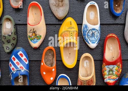 Koog aan de Zaan, Niederlande. Juli 2022. Bunte Clogs vor dem Hintergrund einer Holzwand. Beliebte Souvenirs. Traditionen Hollands. Hohe Qualität Stockfoto