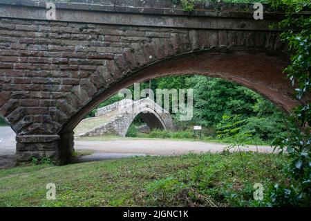 In ganz Großbritannien - Beggars Bridge, Glaisdale, in der Nähe von Whitby, North Yorkshire, Großbritannien (durch die nahegelegene Eisenbahnbrücke betrachtet) Stockfoto