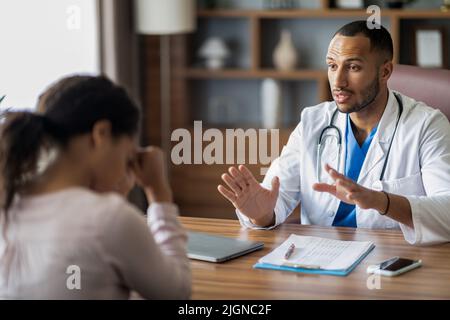 Arzt aus dem Nahen Osten, der sich mit einer verärgerten Patientin unterhalten hat Stockfoto