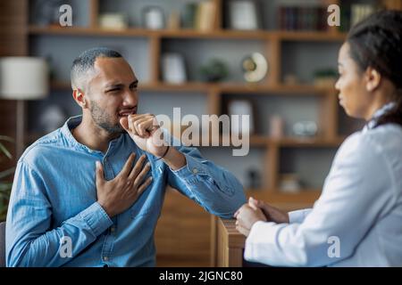 Kranker arabischer Mann hustet und berührt die Brust, besucht einen Arzt Stockfoto