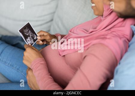 Vorbereitung Auf Die Elternschaft. Glücklich Schwarz Schwanger Muslimischen Paar Blick Auf Baby Sonographie Stockfoto